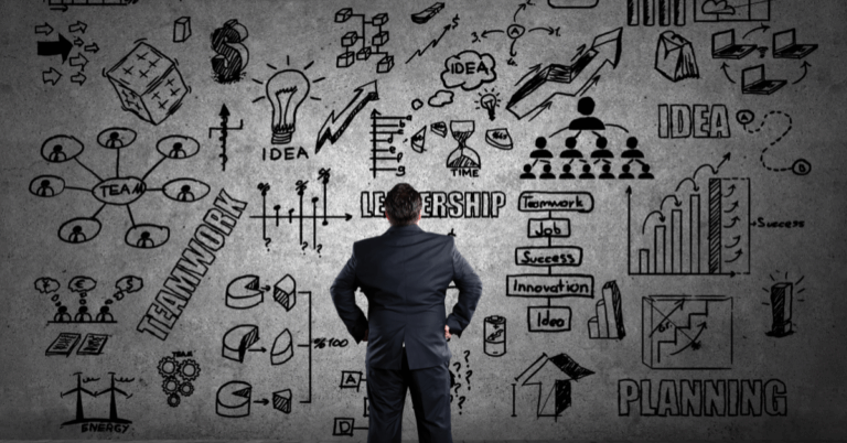 A business professional stands before a wall of strategy sketches illustrating teamwork, leadership, innovation, and planning — representing the complexity of succession in family enterprises.